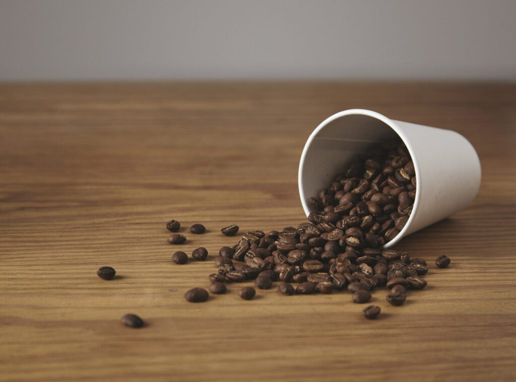 Coffee beans spilled from the cup on table